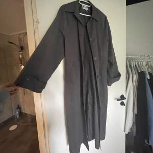 En grå trenchcoat från Nakd som tyvärr inte kommer till användning. Aldrig använd, nyskick. Snygga detaljer och ganska lång. Passar till mycket.