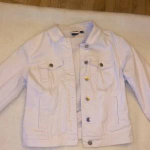 Vit jeansjacka - En vit jeansjacka från Vero Moda i storlek S. Använd några gånger och har en liten fläck på framsidan, men utöver det fortfarande väldigt fräsch! 