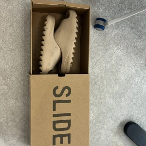 Äkta Yeezy slided - Dom är äkta, skicket är bra förutom att dom är lite smutsiga. Kvittot kommer inte med men orginal lådan gör.