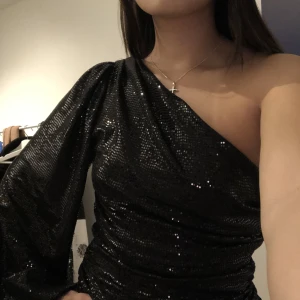 Glittrig nyårs klänning - så sjuuukt snygg klänning använd endast EN gång på min mösspåtagnings middag. Använder aldrig och vill ha en annan klänning så säljer denna. PERFEKTA NYÅRSKLÄNNINGEN.