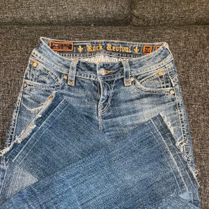 Rock revival  - Lågmidjade jeans från rock Revival.  Fint skick men som ni ser på bild 3 så har den tappat en bokstav men inget man tänker på. Bootcut Strl W28
