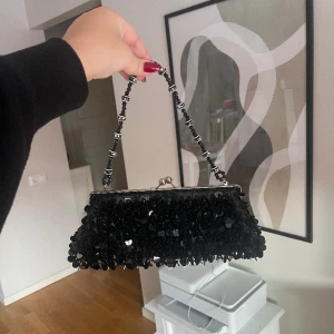 Svart paljett väska  - Svart paljettväska, finns både kort och långt band - Köparen står för frakten - Inga returer - Betalning via köp direkt 