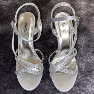Klackskor | Tribeca -  Ett par jättefina silvriga klack skor med strass från märket Tribeca i storlek 37. De har släppt lite i sulan, men det kan enkelt limmas. kan skicka bild på det privat (man kan inte ha fler än 3 bilder) Pris kan diskuteras Skriv privat för mer bilder och