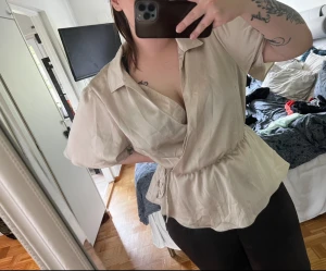 Champagnefärgad omlotttopp - En jättefin champagnefärgad omlotttopp ifrån ASOS i storlek 46. Toppen är endast testad och är i bra skick med inga skador eller liknande ❤️ den är normal i storleken   100% polyester 