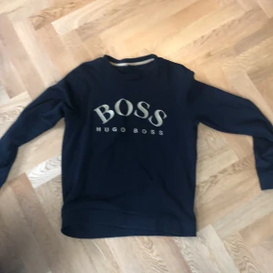 Hugo Boss Tröja - Detta är en Hugo Boss långarmad med den klasiska texten samt i storlek L men liten i storleken så passar M!