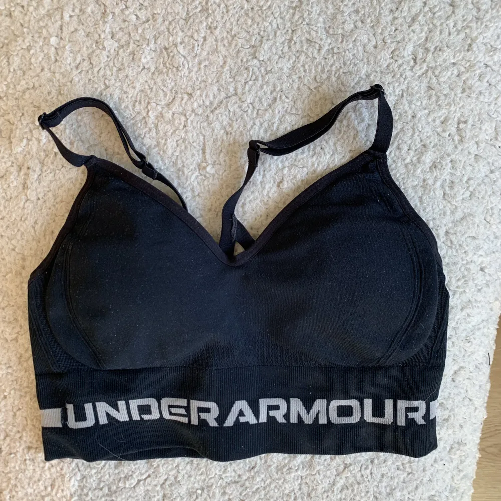 Jättefin sport bh från märket under armour som tyvär inte kommer till användning. Har vadderingar i men som går att ta ut. Storlek S Sparsamt använd! . Toppar.