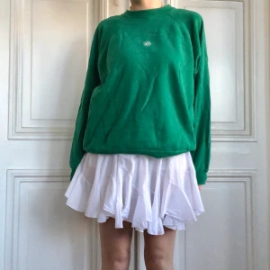 söt grön sweatshirt med broderad blomma på - jättefin vintage grön oversized crewneck sweatshirt med handbroderad vit blomma på framsidan! skick: använd, har lite svårsedda blekningsfläckar på ärmen storlek: XL modell: s/m 169cm