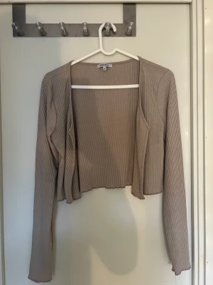 Kofta/bolero - En beige kort kofta/bolero perfekt över ett fint linne.