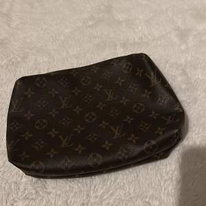 En louis vuitton clutch som även kan användas som en necessär, inte äkta