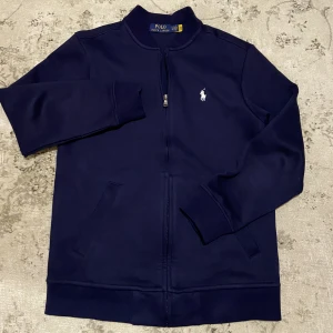 Ralph Lauren double knit full-zip sweater - Tjena! Säljer nu dena det snygga Ralph Lauren double knit full-zip sweater som är fortfarande i topp skick 9,5/10. Ny pris 1999kr mitt pris 649kr. Pris och bilder kan diskuteras privat. Mvh Alend 😁