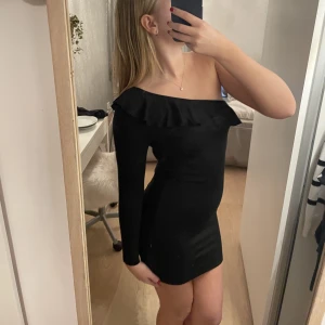 Trendig enarmad klänning - En klänning med en arm och en snygg volange. Mycket trendig och snyggt figursydd. Inga reflektera eller tecken på användning och endast använd ett fåtal gånger!
