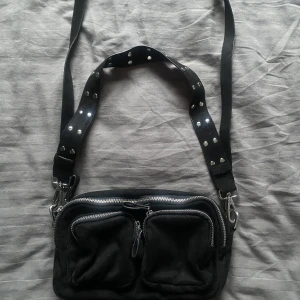 Väska - Säljer denna jätte fina väska som går att ha på massa olika att tillkommer två olika band! Massa praktiska fack! Ny skick!