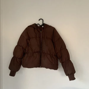 Kort puffjacka - Kort brun puffjacka med luva! Varm och fodrad. Storlek S. Synligt använd, men kan tvättas innan köp. Säljes för 150kr. ❄️