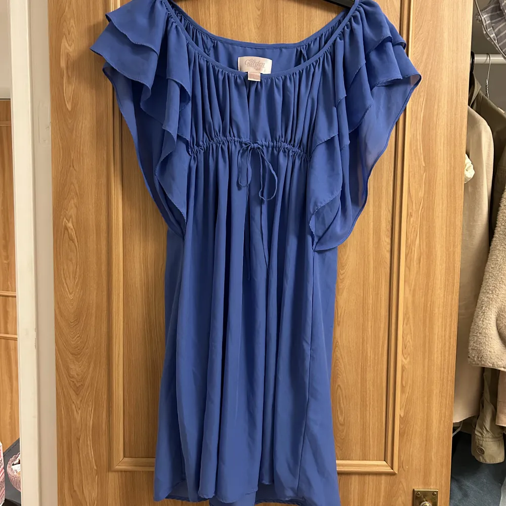 Blå klänning med söta volangärmar, knappt använd, säljer då den är för stor<3. Klänningar.
