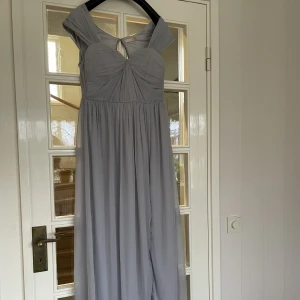 Balklänning  - Säljer min fina balklänning från Nelly som endast är använd en gång. Längden är uppsydd så den passar mig som är 163 cm med 9 cm klack. Färgen är grå/ljuslila