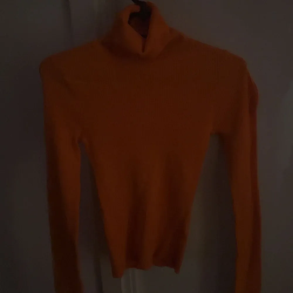 En orange plotröja som är varm och skön i materialet . Skjortor.