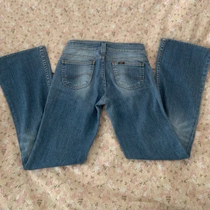 Lee låmidjade bootcut jeans - Säljer mina lågmidjade Lee jeans då de är för små och korta på mig som är 172. Innerbenslängden är 76cm och midjemåttet är 37cm rakt över. de är aldrig använda och i väldigt bra skick. kontakta vid frågor intresse eller bilder (helst inte på då jag knappt får på dom)💗