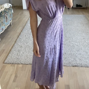 Lila klänning - Litet hål vid slitsen som enkelt går att fixa. Märks annars inte av. 