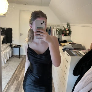 Svart klänning  - Svart kort satin klänning, helt ny