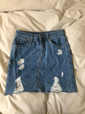 Jeanskjol med hål 💙 - En fin jeanskjol med hål från h&m i storlek 32 💙 den är i bra skick men har blivit för liten för mig. 