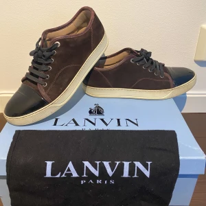 Lanvin Patent Cap Toe Sneaker Ruby - Hej, säljer ett par sjukt snygga vinröda Lanvin Cap Toe sneakers i mycket bra skick. Storlek 7 vilket motsvarar 42/43. Nypris runt 4000kr. Ovanlig färg. Dustbag medkommer. Både mocka samt ToeBox i mycket bra skick.Priset är inte hugget i sten. Hör av dig!