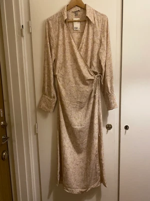 Omlottklänning - Blommig maxiklänning med omlott. Helt ny och oanvänd med prislappen kvar.