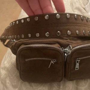 Väska  - Säljer min Noella väska som inte kommer till användning längre. Den är använd och lite sliten men inget som märks. Alla dragkedjor funkar och tillkommer ett längre band!🤩