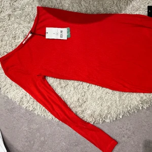 Klänning - En helt ny röd klänning från nakd, prislappen kvar! Klänningen är ribbad, en ärm och den är ungefär till knäna✨ Vid flera frågor/ bilder kontakta mig här!
