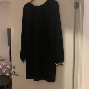 Fin svart klänning med pärl detaljer  - Säljer en fin känning från hm med pärl armar.