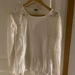 vit Långärmad tröja med spets på båda sidor och en volang längst ner storlek Medium och kommer ifrån Gina tricot.