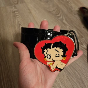 Betty Boop bälte rare  - Säljer mitt fina betty boop bälte då det inte kommer till användning Släpper det inte billigt då det är eftertraktat Börjat gå itur men går säkert att laga enkelt med limm eller att sy 