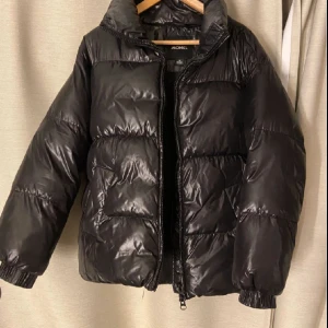 Svart glansig jacka  - Lånad bild! Men exakt samma jacka! Säljer denna glansiga svarta pufferjacka från monki, använd 5 gånger ungefär och nypris runt 700 skulle ja tro! Storlek S men känns mer som M🫶🏼