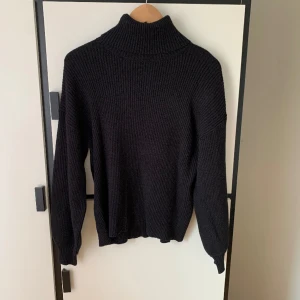 Stickad polotröja - En stickad polotröja, svart. Ser ut som ny och har aldrig använt den.  Obs. Plagget kommer att tvättas innan det skickas iväg.