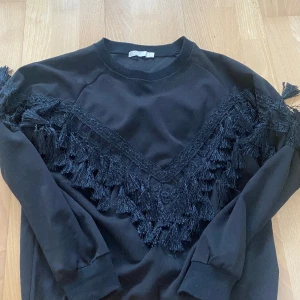 Topp med pompom - Det är mellan en hoodie och en t shirt med långa armar! (Det är inte med en fleece insidan)  Bra för festen! 