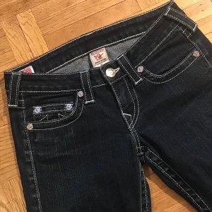 True religion jeans! - Så sjukt snygga trueys som sitter så fint!💕De är lågmidjade och bootcut modell, innerbenslängden: 74cm och mått rakt över midjan: 38cm. Kanten där nere är uppsprättad men det är inget som märks.💛Säljer då de är lite korta för mig! Skriv för fler bilder! 🫶
