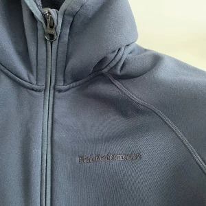 Fleecetröja  - Marinblå fleece från peak performance. Dragkedja och luva. Perfekt under skidjacka. 