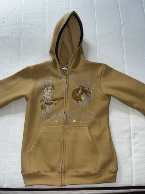 Aim for the moon hoodie (golden) - Hej, jag säljer min aim for the moon hoodie, Size = M, använd 1 gång. Värde 650kr,