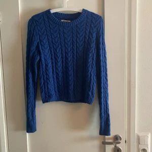 Blå stickad tröja  - En blå stickad tröja, 55% Cotton 25% recycled polyester 20% acrylic 