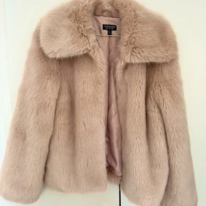 Pälsjacka  - Säljer denna sjukt fina pälsjacka i beige/rosa färg. Aldrig använd! 