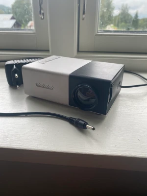 Pro,jektor - Köpte för 450 och säljer för 360, bra bild men sämre ljus så koppla upp en högtlare. Använt 2 gånger och funkar bra, inget internt batteri så funkar bara med 240v eller eluttags kabeln.