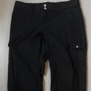 Svarta Nelly byxor - Svarta lågmidjade byxor i storleken 36💕 Dom är från Nelly och kan spännas nere vid fötterna.  