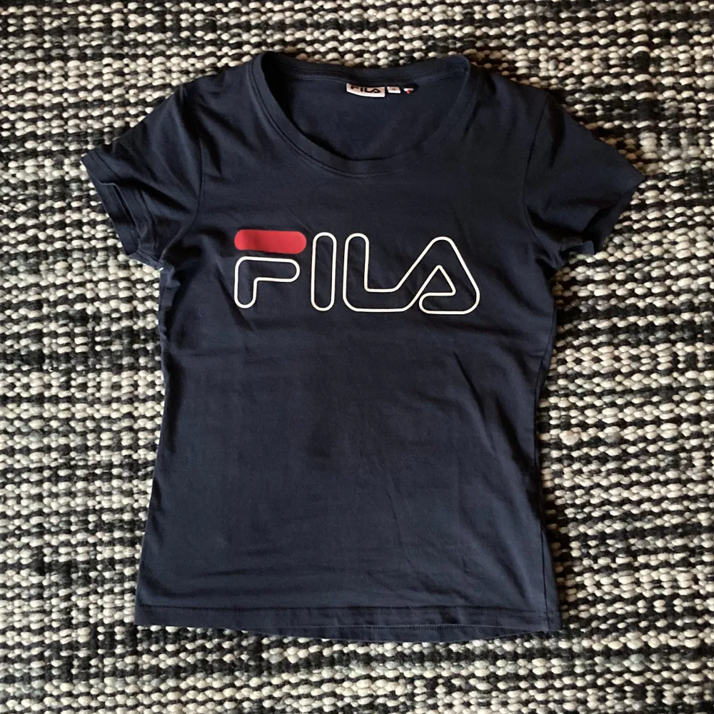 Retro Fila-tröja i asnajs passform. Tajt överkropp men lösare runt midjan. Köpt second hand i Berlin men endast använt 1 gång av mig. Kontakta mig vid intresse!⭐️⭐️. T-shirts.