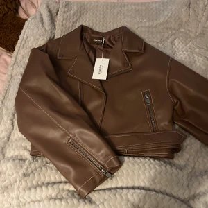 Skinnjacla - En superfin brun skinnjacka från Nelly x Bianca. Den är storlek 34 men väldigt oversize, säljer då den aldrig kom till användning. Prislappen är kvar!