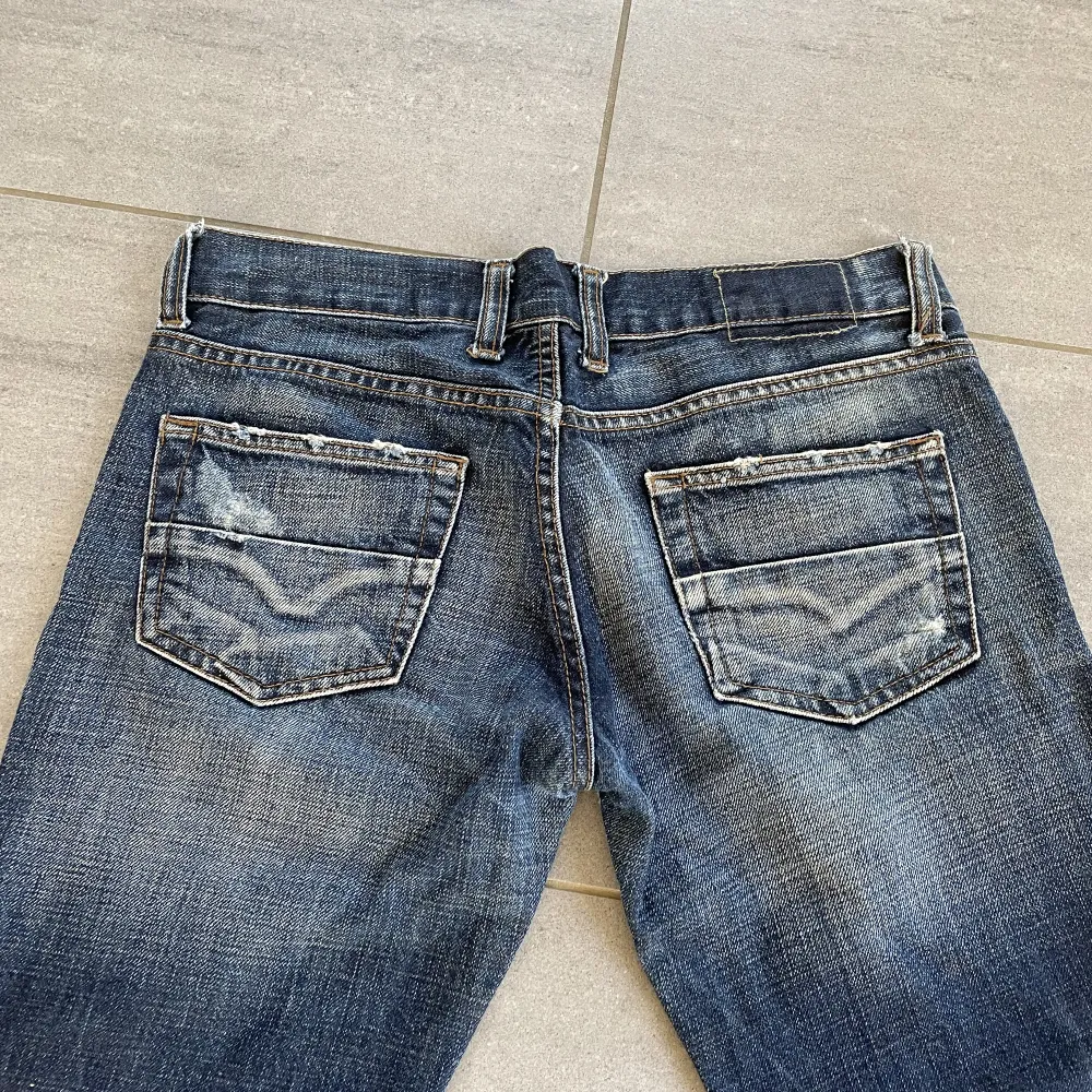 Lågmidjade jeans från diesel  med cool detalj i midjan. På lappen stor det size 30, men jag har strl 27 i midjan och de är lite små på mig. En knapp vid gylfen saknas, men den behövs inte för att det finns andra knappar. Meddela mig om funderingar❤️. Jeans & Byxor.