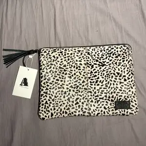 Här har vi en leopardmönstrad handväska ifrån Affari of sweden med svarta detaljer väskan är gjord i fake päls. På insidan av väskan hittar vi korthållare men även stort utrymme för andra föremål samt en ficka med dragkedja, ALDRIG ANVÄND