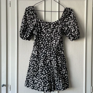 Blommig playsiut H&M   - En jumpsuit med korta ben, puffärmar och hjärtformad urringning. Stängs med gylf och knapparna i fram. Den har framfickor! Köpt för några år sedan men aldrig använd, nypris 349kr. 🌷  OBS: Liten i storleken! 