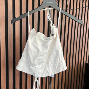 Topp - Croppad topp som man knyter där bak. Aldrig använd. Nypris 299kr. Prislapp kvar.