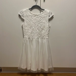 Studentklänning - Suuperfin helvit sommarklänning/studentklänning!! Strl 38 men sitter som 36. Broderad upptill. Djup rygg. Inga tecken på defekthet, använd en gång. Nypris 600