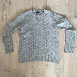 Stickad Gant tröja - Ljusgrå stickad Gant tröja.  - Litet hål på höger bakarm - Storlek 170cm 