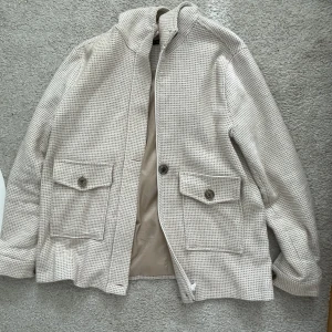 Beige kort kappa - Säljer denna fina jacka då den ej kommer till användning! Perfekt inför våren🥰Köparen står för frakt! Köpt på Zalando❤️Storlek 40 men sitter ej oversize på mig som har M vanligtvis:) 